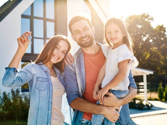 Happy family with keys to their new home