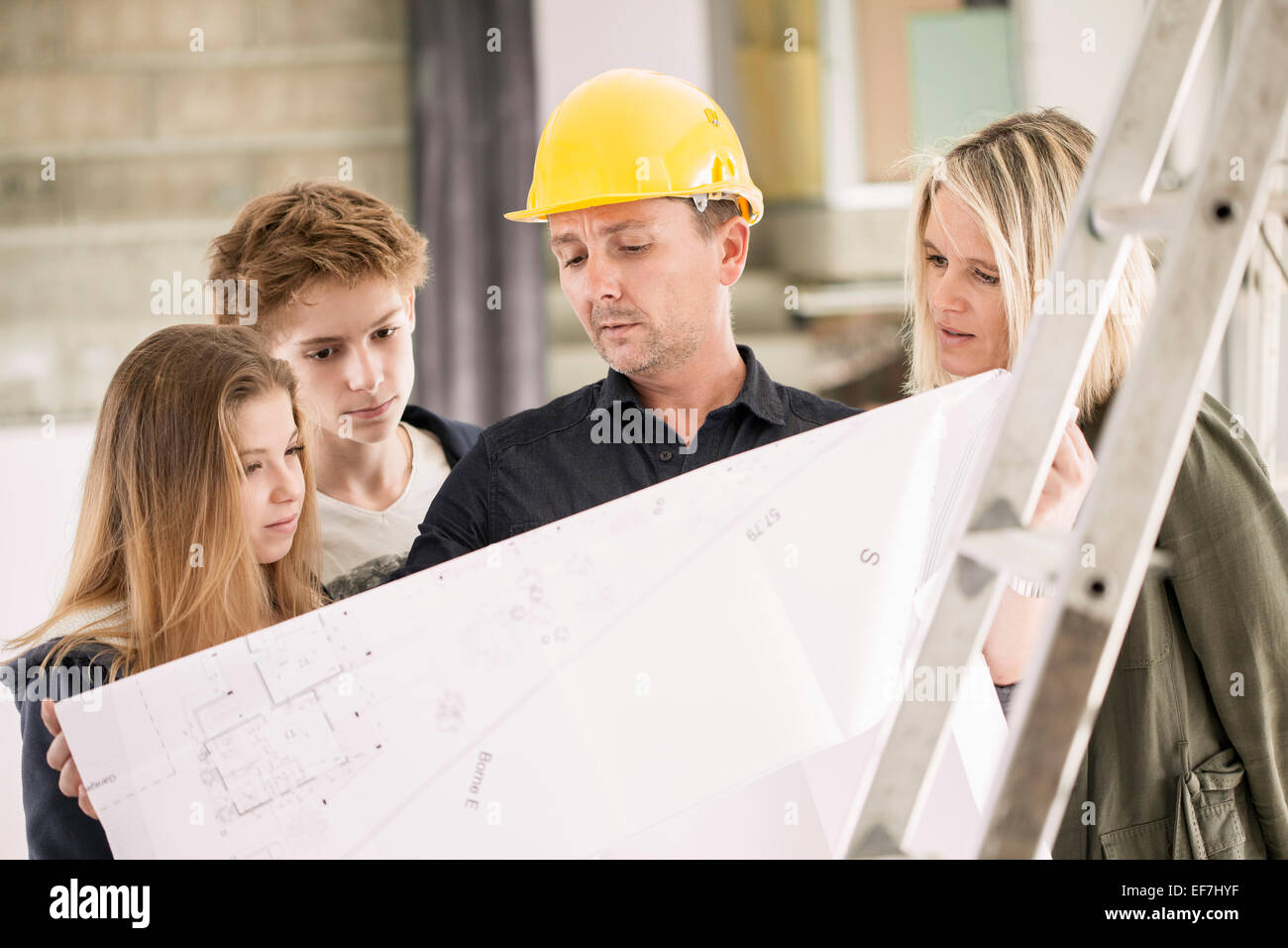 Family reviewing blueprints for new home construction